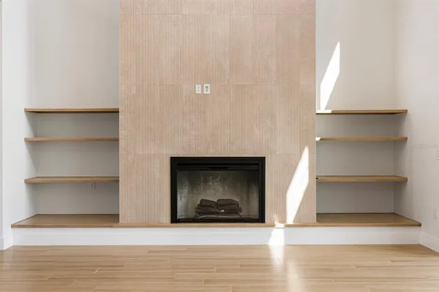 a view of an empty room with a fireplace and a window