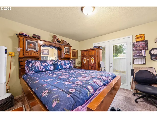 a bedroom with a bed and dresser with mirror