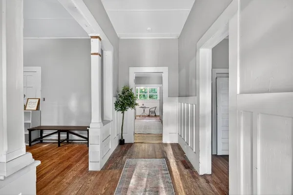 a hallway with wooden floor and furniture