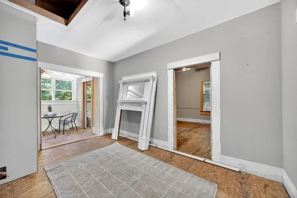 a view of a livingroom with wooden floor and a fireplace