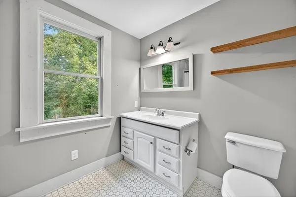 a spacious bathroom with a toilet sink and mirror