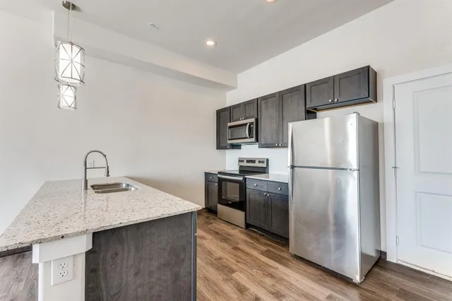 a view of kitchen with stainless steel appliances refrigerator oven and cabinets