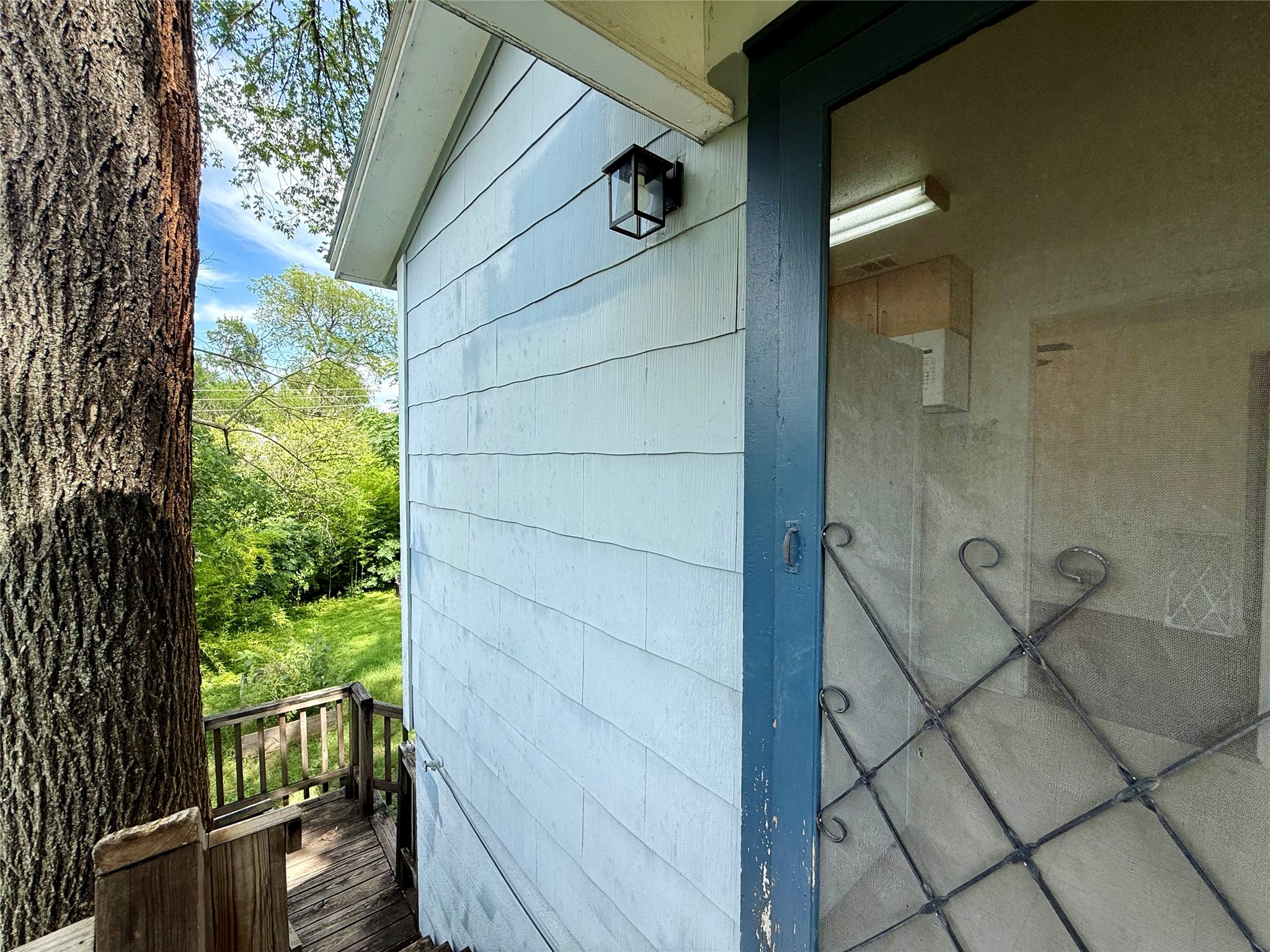 3305 Merrie Lynn Avenue Austin, TX 78722 - Photo 17 of 22 A tranquil wood-sided exterior with a charming wooden deck, nestled amongst verdant trees.