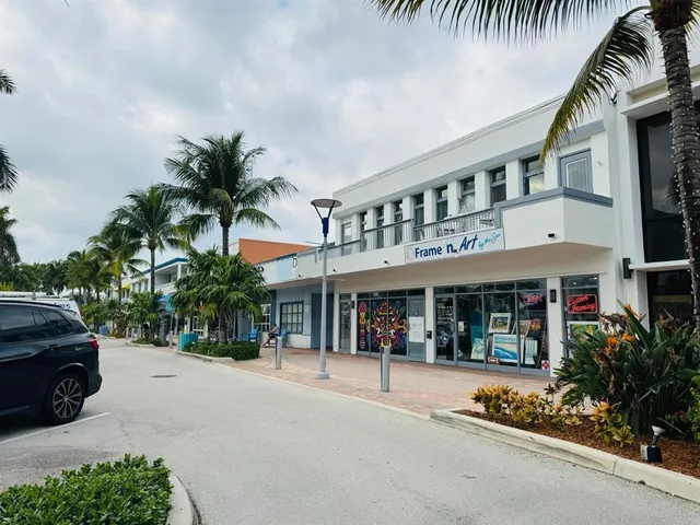 a view of a building and car parked on the road