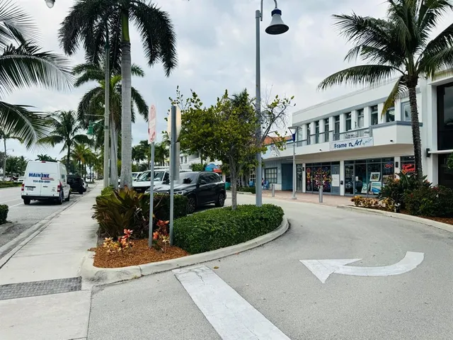 a front view of a building with palm trees