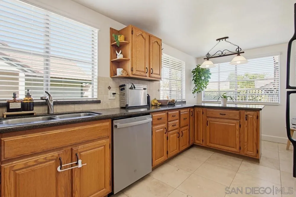 431 Nantucket Escondido, CA 92027 - Photo 14 of 30 a kitchen with stainless steel appliances granite countertop a sink a stove cabinets counter space and a window