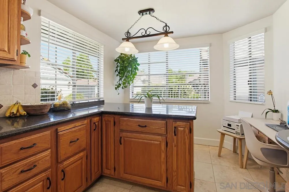 431 Nantucket Escondido, CA 92027 - Photo 16 of 30 a kitchen with stainless steel appliances granite countertop wooden cabinets a sink and a window