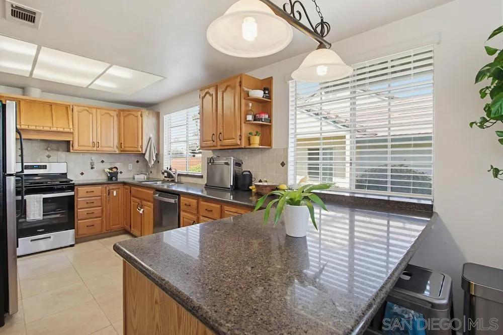 431 Nantucket Escondido, CA 92027 - Photo 17 of 30 a kitchen with stainless steel appliances granite countertop sink stove top oven and cabinets