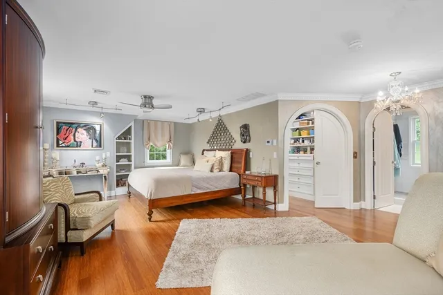 a bedroom with a large bed and a chandelier