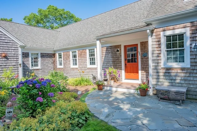 a front view of a house with a yard and potted plants