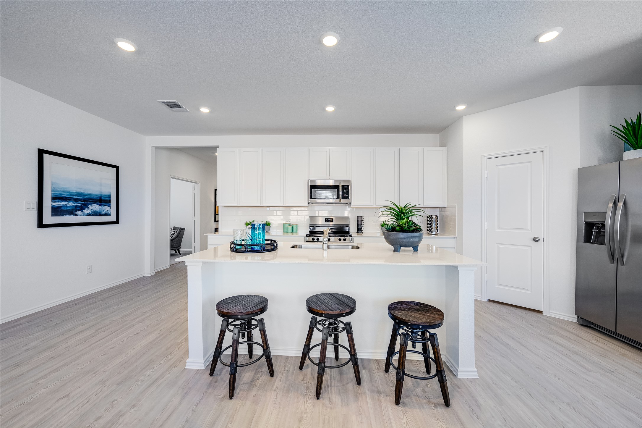 104 Stumpy Street San Marcos, TX 78666 - Photo 2 of 23 Kitchen with stainless steel appliances, an island with sink, light wood-style floors, recessed lighting, and backsplash