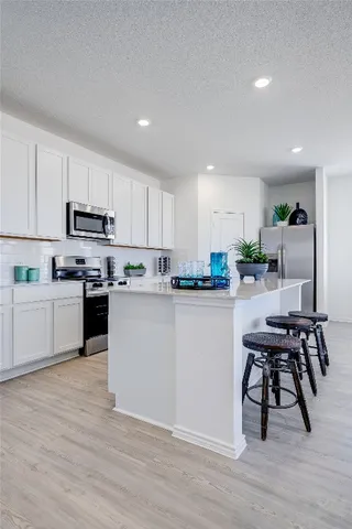 a kitchen with a table chairs microwave and cabinets