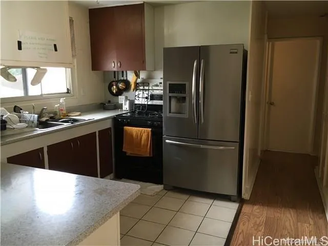 a kitchen with a sink a refrigerator and a stove top oven