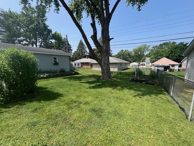 211 Koch Drive Genoa, IL 60135 - Photo 29 of 29 a view of backyard with a table and chairs under an umbrella