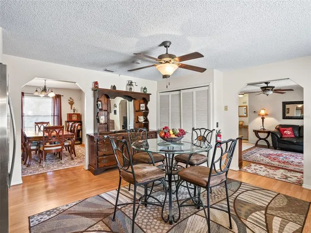a view of a dining room and livingroom with furniture a rug a chandelier and wooden floor
