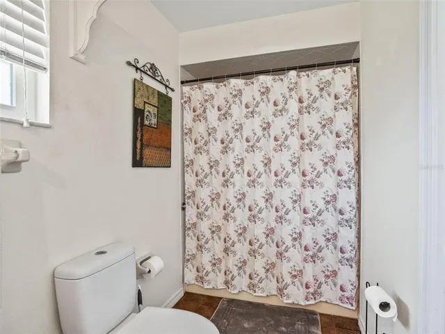 a white toilet sitting next to a shower curtain