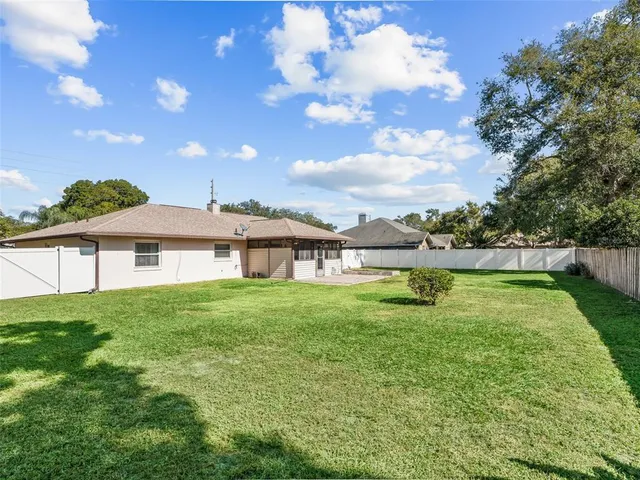 a view of a big yard with a house in the background