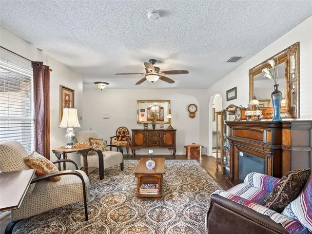 a living room with furniture fireplace and a large window