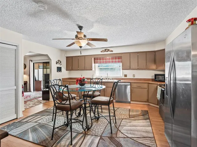a kitchen with stainless steel appliances kitchen island granite countertop a dining table and chairs