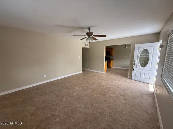 an empty room with windows and fan