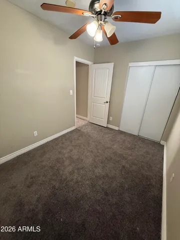 an empty room with a window and a fan