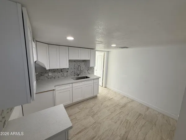a kitchen with granite countertop white cabinets and stainless steel appliances