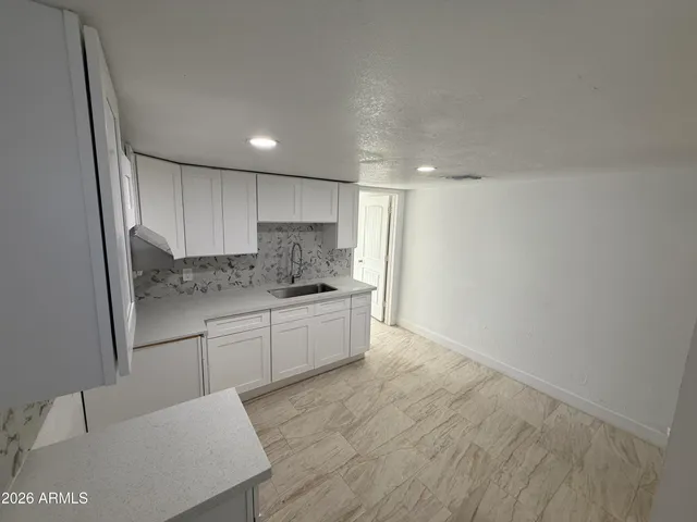 a kitchen with granite countertop white cabinets and stainless steel appliances