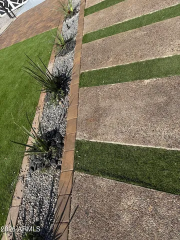 a vase with flowers sitting on the side of a road