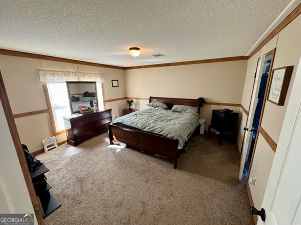 a bedroom with a bed and a mirror on the dresser