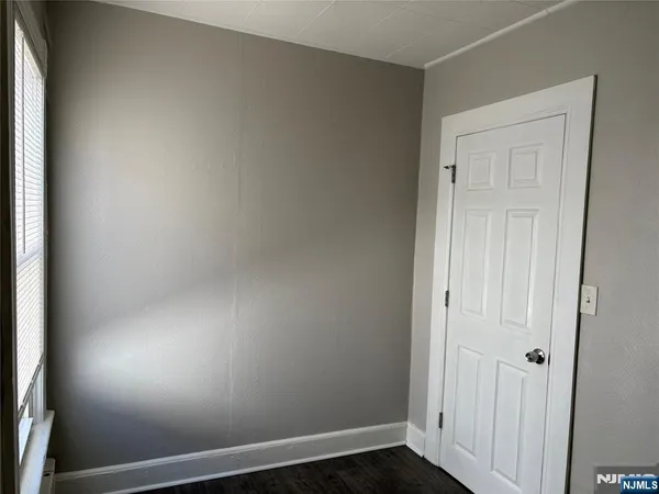 an empty room with wooden floor and closet