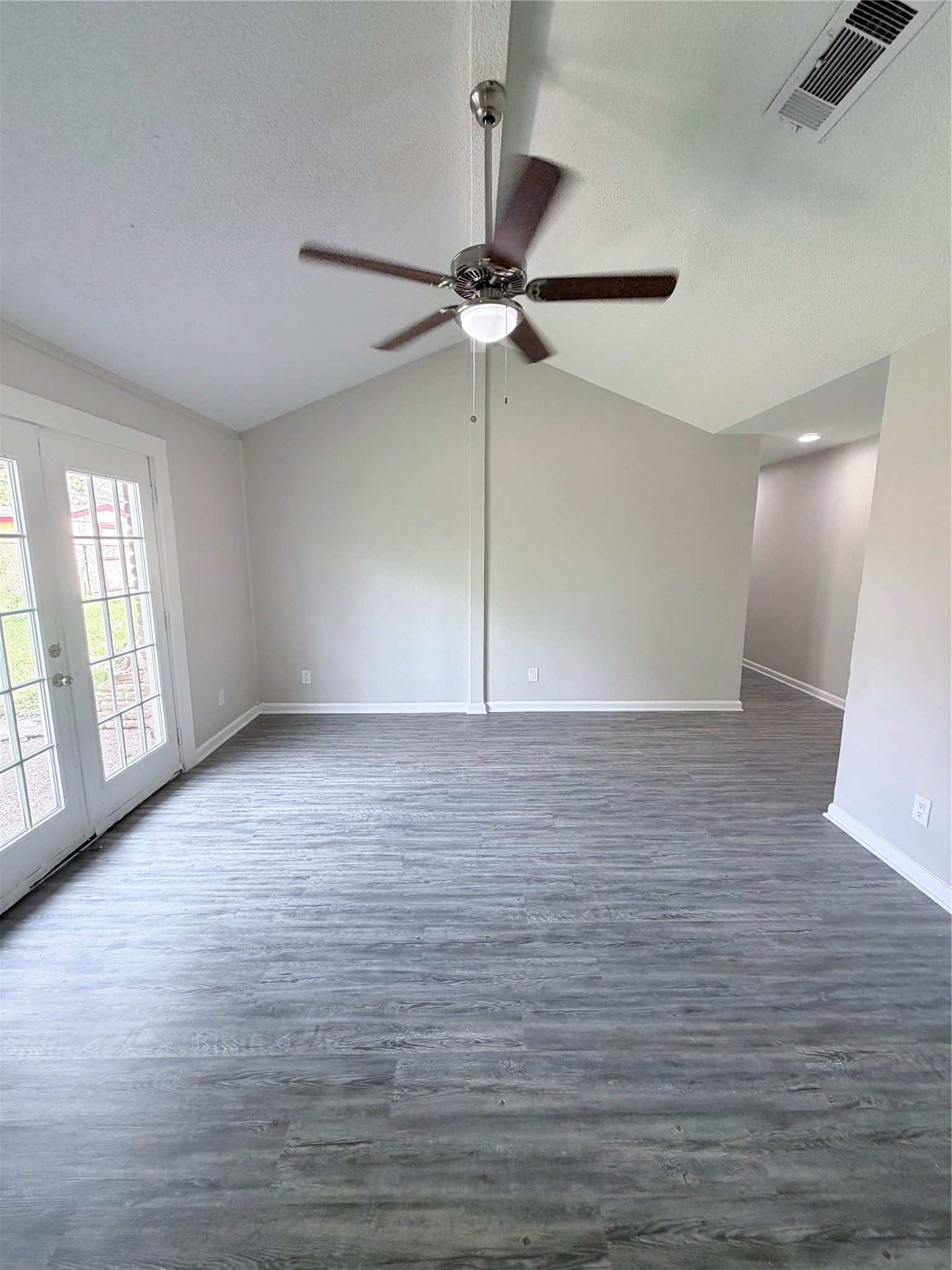 7705 Parker Road Houston, TX 77016 - Photo 3 of 17 an empty room with wooden floor fan and windows