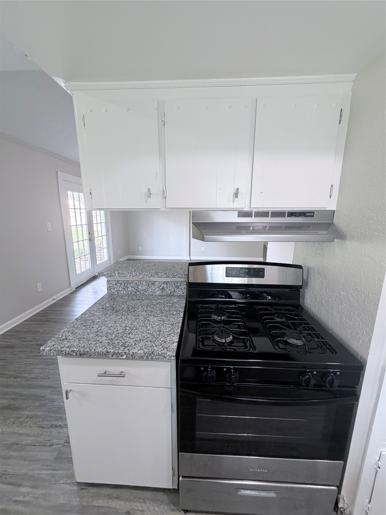 7705 Parker Road Houston, TX 77016 - Photo 10 of 17 a kitchen with granite countertop white cabinets and a stove