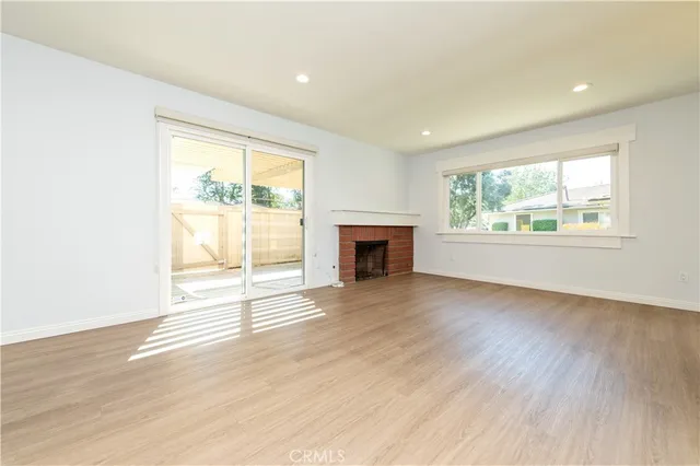wooden floor fireplace and windows in an empty room