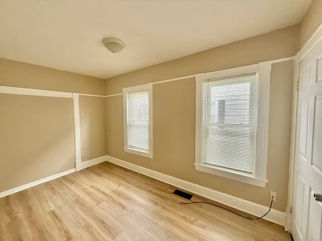 a view of a room with wooden floor and windows
