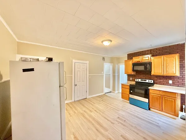 a kitchen with stainless steel appliances kitchen island granite countertop a refrigerator and a stove top oven