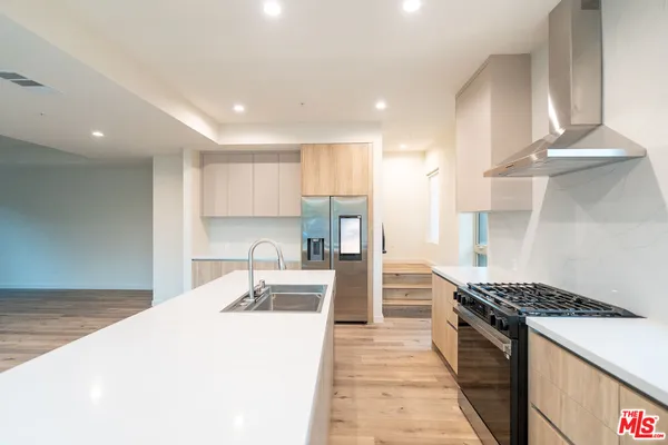 a kitchen with stainless steel appliances granite countertop a sink stove and refrigerator