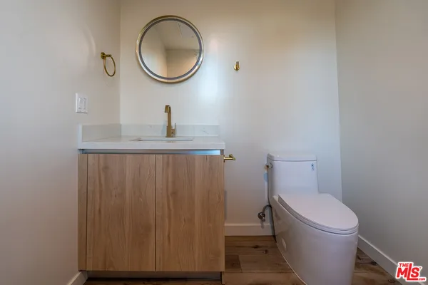 a bathroom with a toilet a sink and a mirror