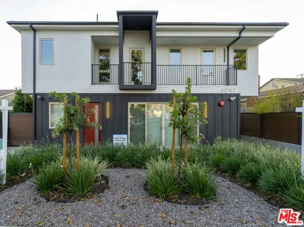a view of a house with potted plants and a table