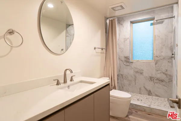 a bathroom with a sink a toilet and a mirror