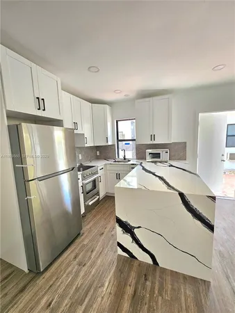 a kitchen with stainless steel appliances a refrigerator sink and cabinets