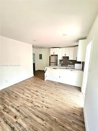 a view of kitchen with refrigerator sink and wooden floor