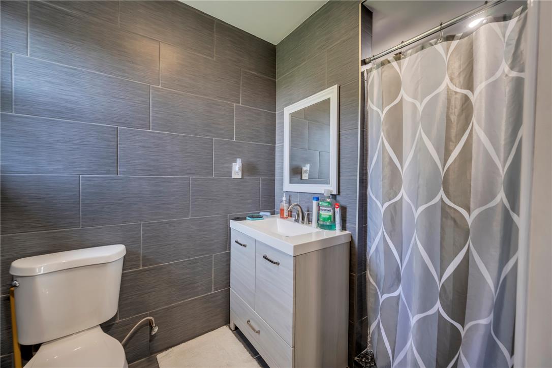 439 Cherry Hill Road Nazareth, PA 18064 - Photo 14 of 31 A well-appointed bathroom features sleek tile walls, a modern vanity, and a shower with an elegant curtain.
