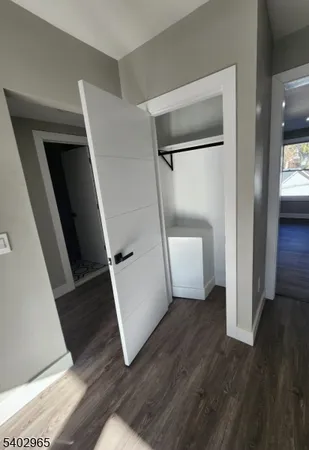 a view of a hallway with wooden floor and stairs