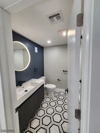 a bathroom with a sink a toilet and a mirror