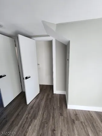 an empty room with wooden floor and white doors