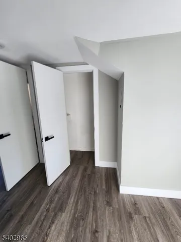 an empty room with wooden floor and white doors