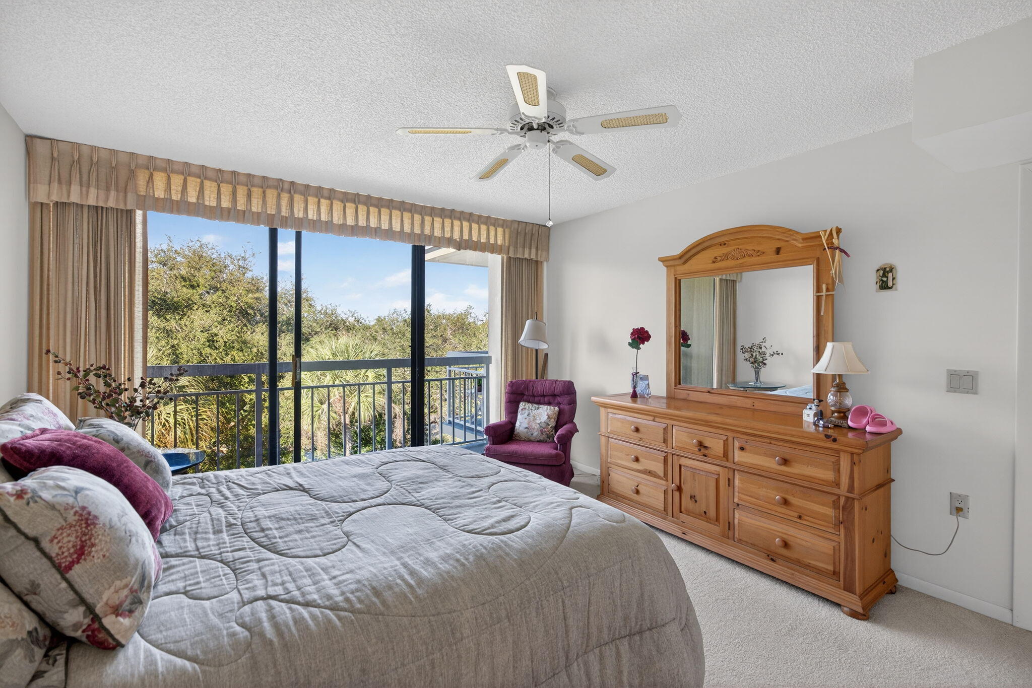 2581 Village Boulevard, Unit 401 West Palm Beach, FL 33409 - Photo 12 of 24 a bedroom with a bed and large windows