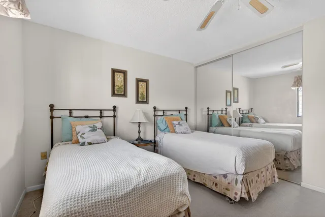 a bedroom with two beds and painting on the wall