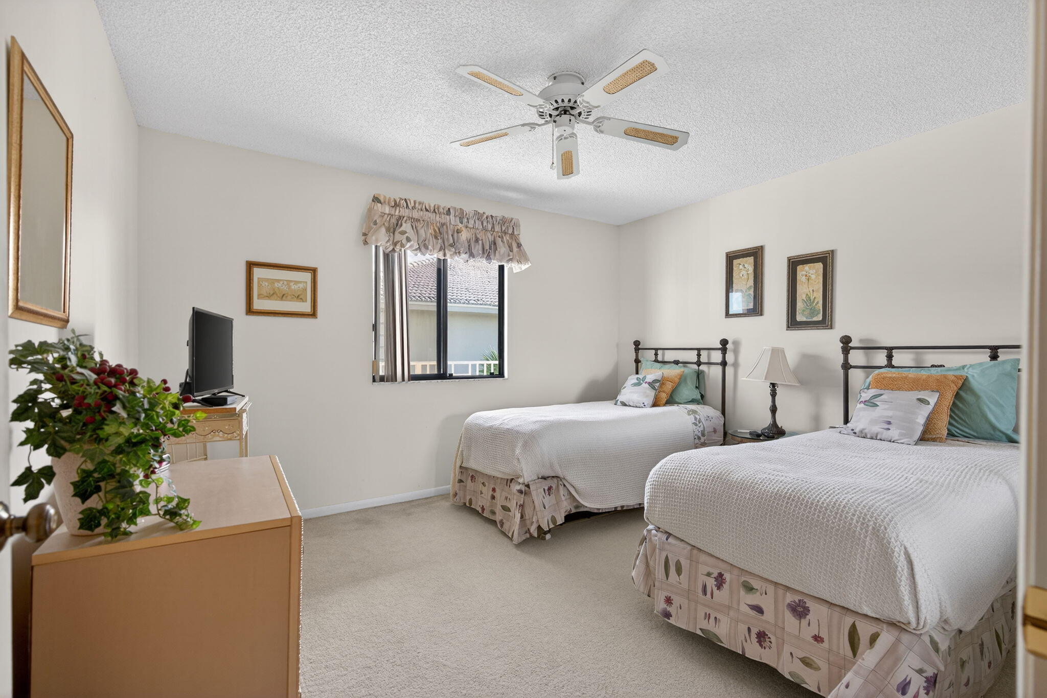 2581 Village Boulevard, Unit 401 West Palm Beach, FL 33409 - Photo 17 of 24 a bedroom with two beds and a potted plant