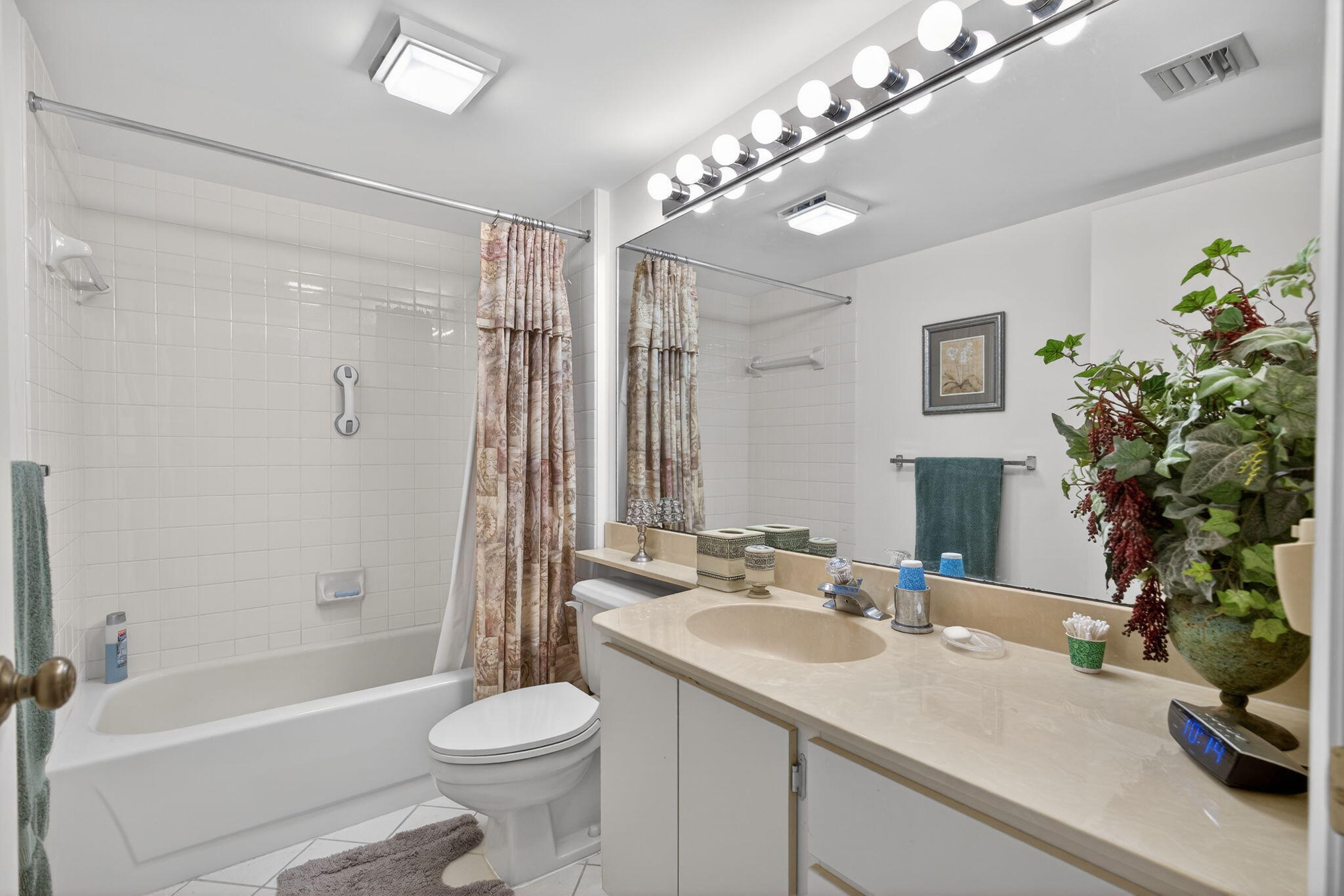 2581 Village Boulevard, Unit 401 West Palm Beach, FL 33409 - Photo 18 of 24 a bathroom with a sink a toilet a large mirror and shower